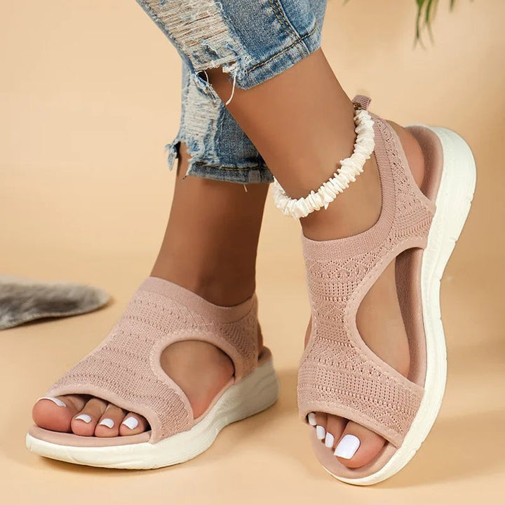 Blush pink knitted sandals featuring peep-toe design and cushioned white platform