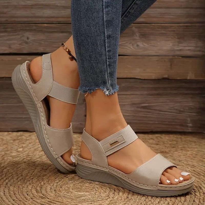 Taupe wedge sandals showing cut-out ankle strap and ribbed sole