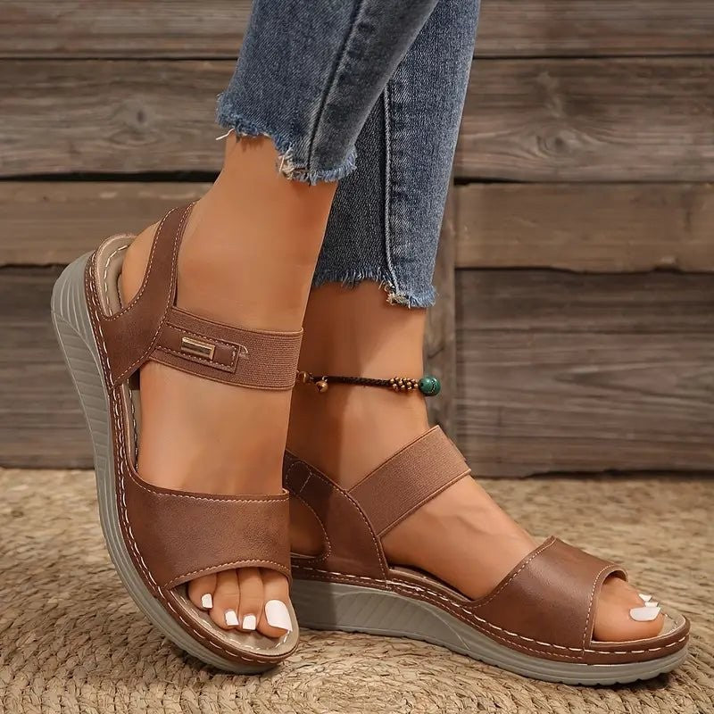 Brown wedge sandals with layered straps and contrast stitched sole