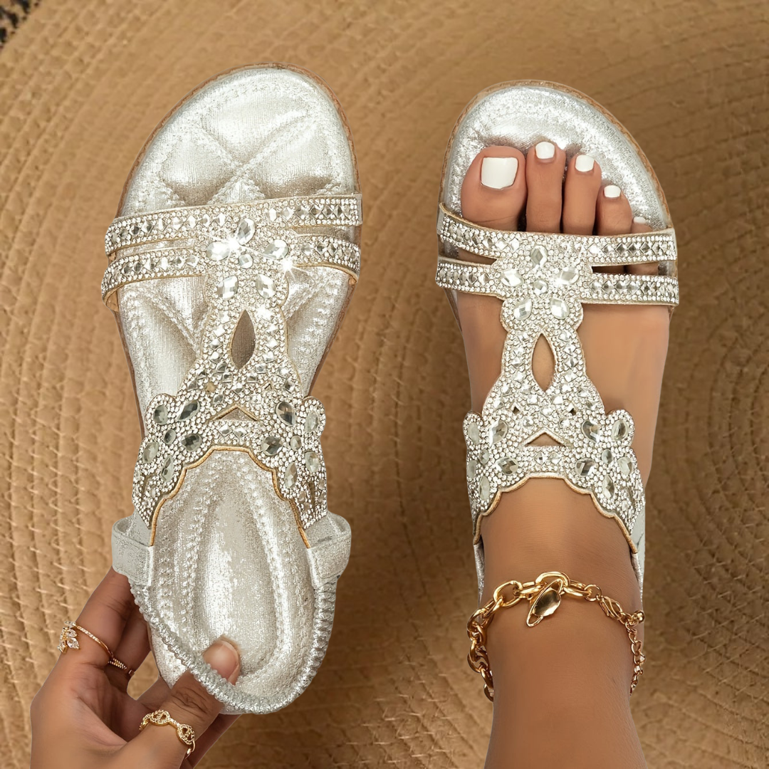 Teal rhinestone flat sandals worn on feet, paired with a gold anklet chain