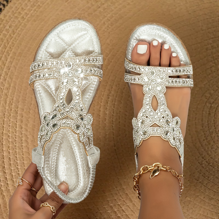 Teal rhinestone flat sandals worn on feet, paired with a gold anklet chain