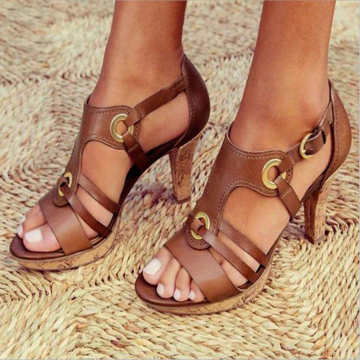 Tan leather gladiator-style heeled sandals featuring cork platform and buckle strap