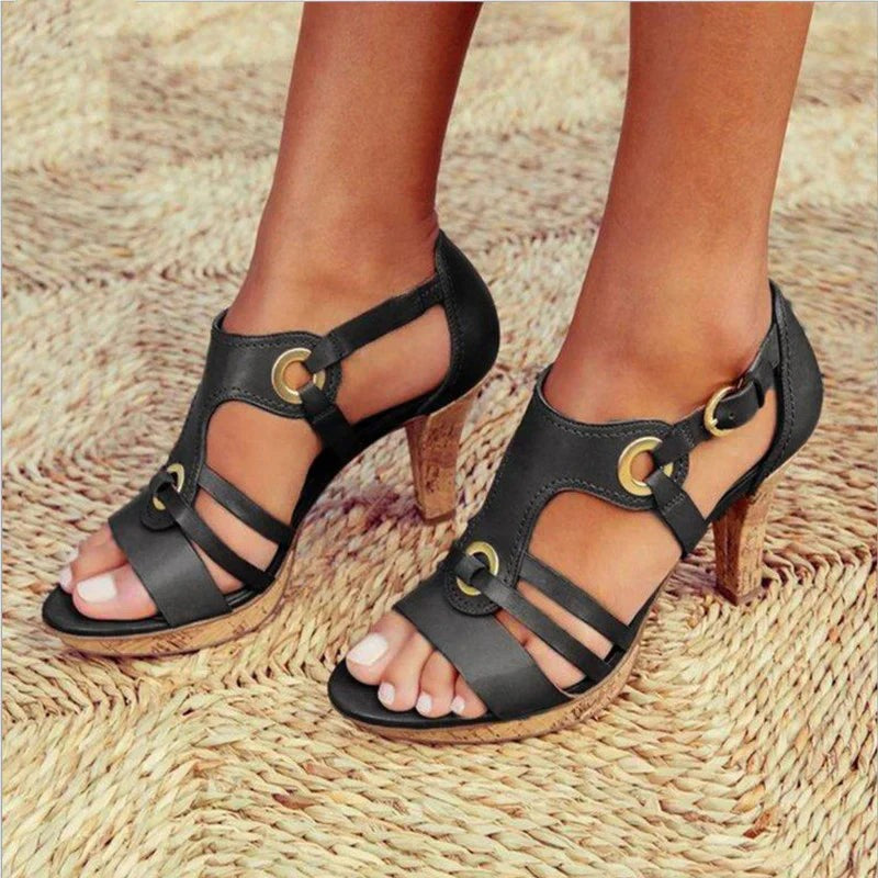 Black strappy open-toe heels with cork stiletto heel and ankle buckle fastening