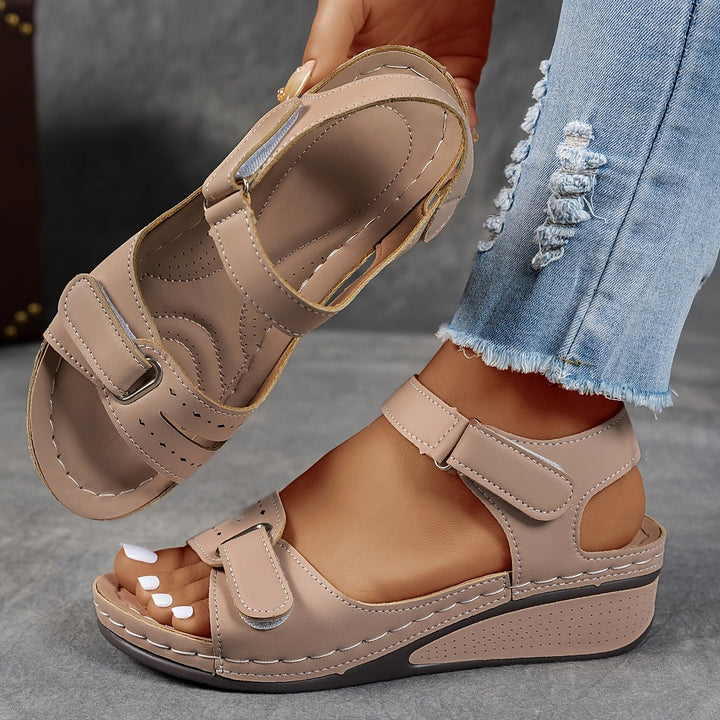 Beige open-toe wedge sandal with padded insole and secure touch-fastening straps