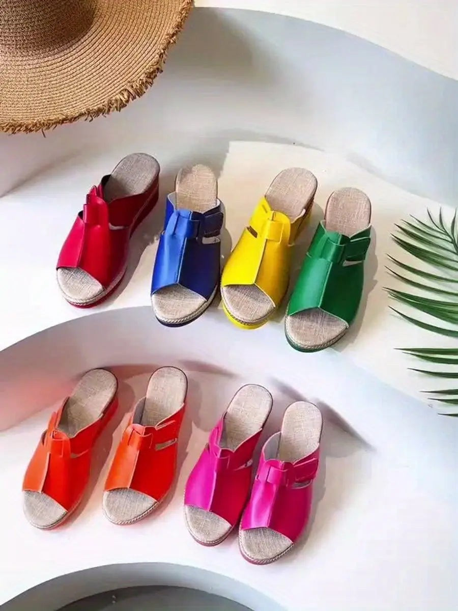 Rainbow selection of women's espadrille wedge sandals arranged in matching pairs