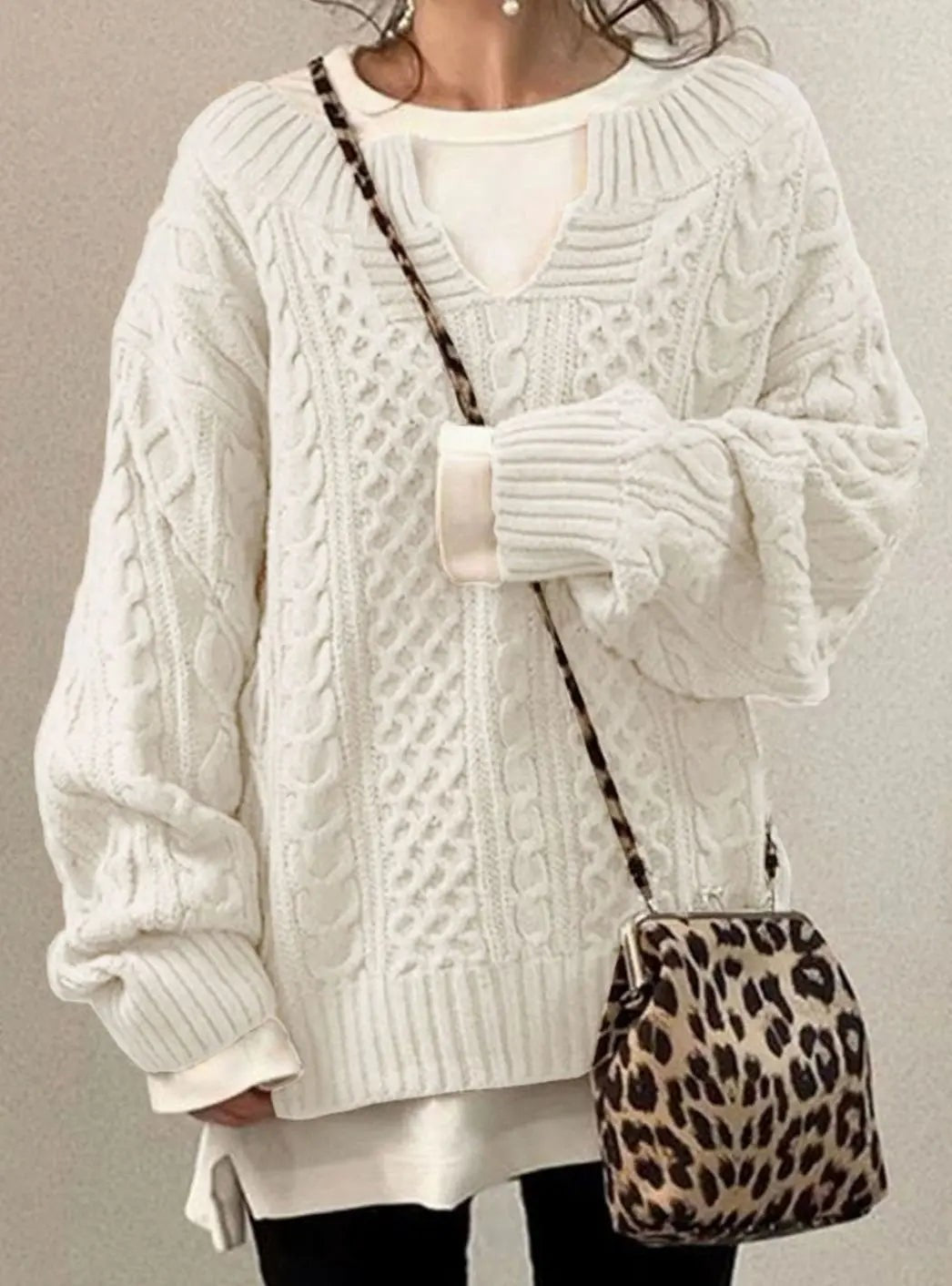 Cream cable knit jumper with layered white top and leopard print crossbody bag