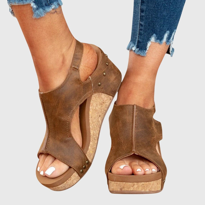 Studded brown wedge sandals featuring cut-out ankle straps and cork sole
