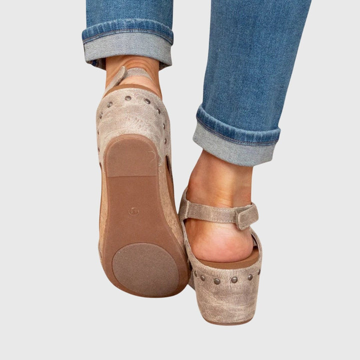 Rear view of taupe cork-wedge sandals showing textured rubber outsole