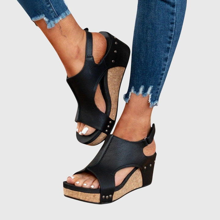 Close-up of black cork-wedge sandals highlighting cut-out side panels