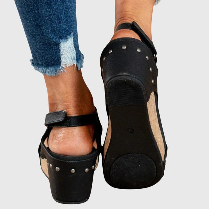Rear view of black studded wedge sandals showing chunky platform sole
