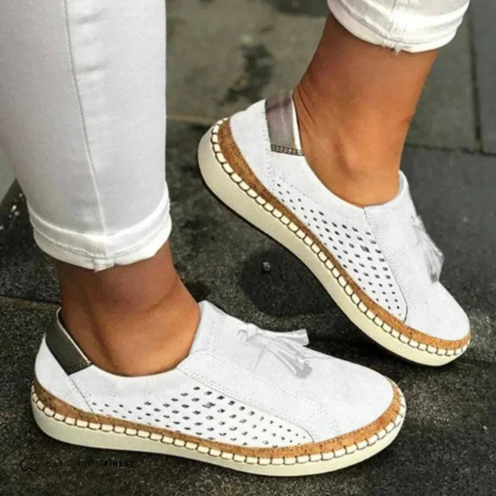 White suede slip-on sneakers with perforated cutouts and tan cork edge