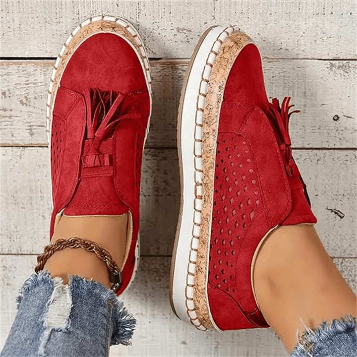 Pair of red tasselled slip-on trainers with cork sole shown from above