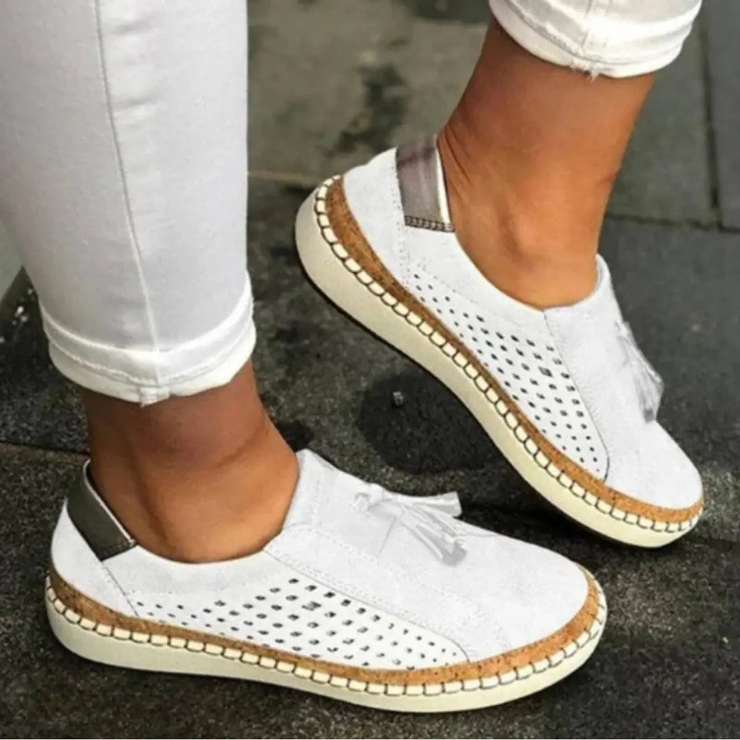 White suede slip-on trainers with breathable perforated sides and tassel accent