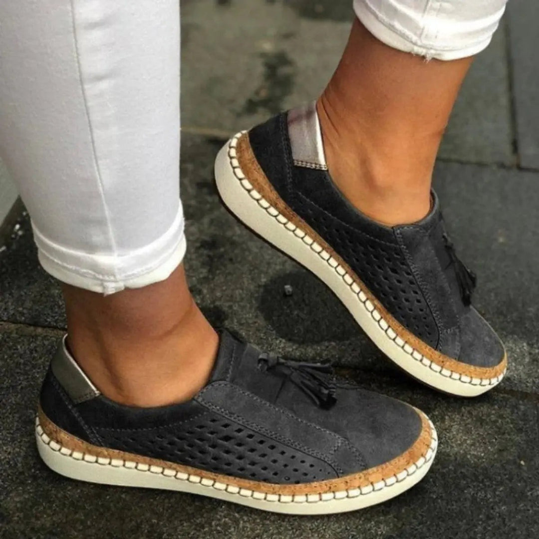 Charcoal grey suede slip-on trainers with perforated cutouts and tassel detail