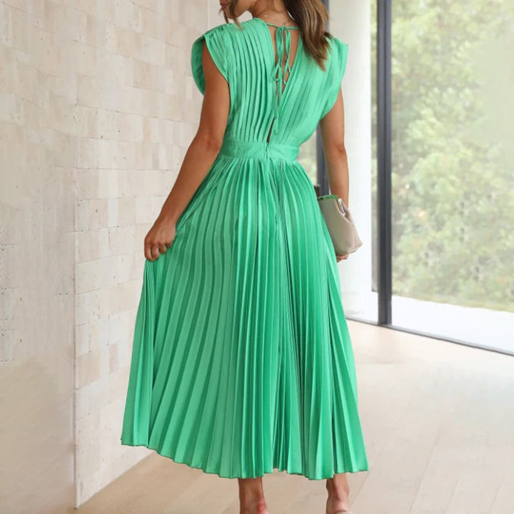 Emerald green pleated dress showing tie-back detail and flowing skirt