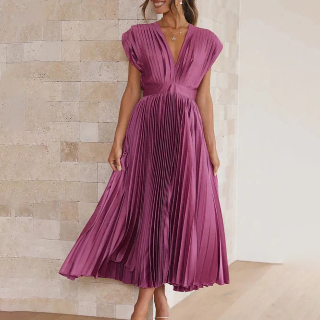Magenta pleated satin midi dress with deep V-neckline, worn with heels