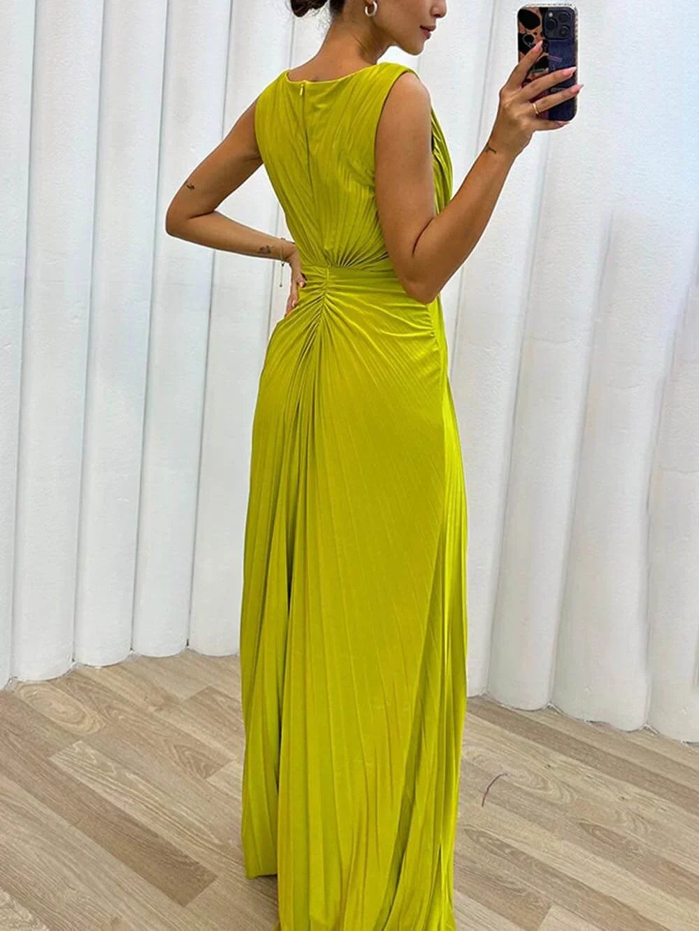 Rear view of chartreuse pleated maxi dress showing ruched back detailing