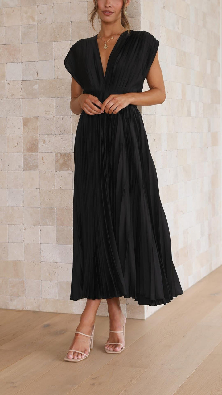 Black pleated satin dress paired with nude strappy block heels