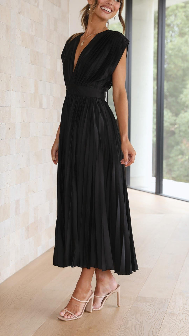 Rear view of black pleated dress showing open back with tie fastening