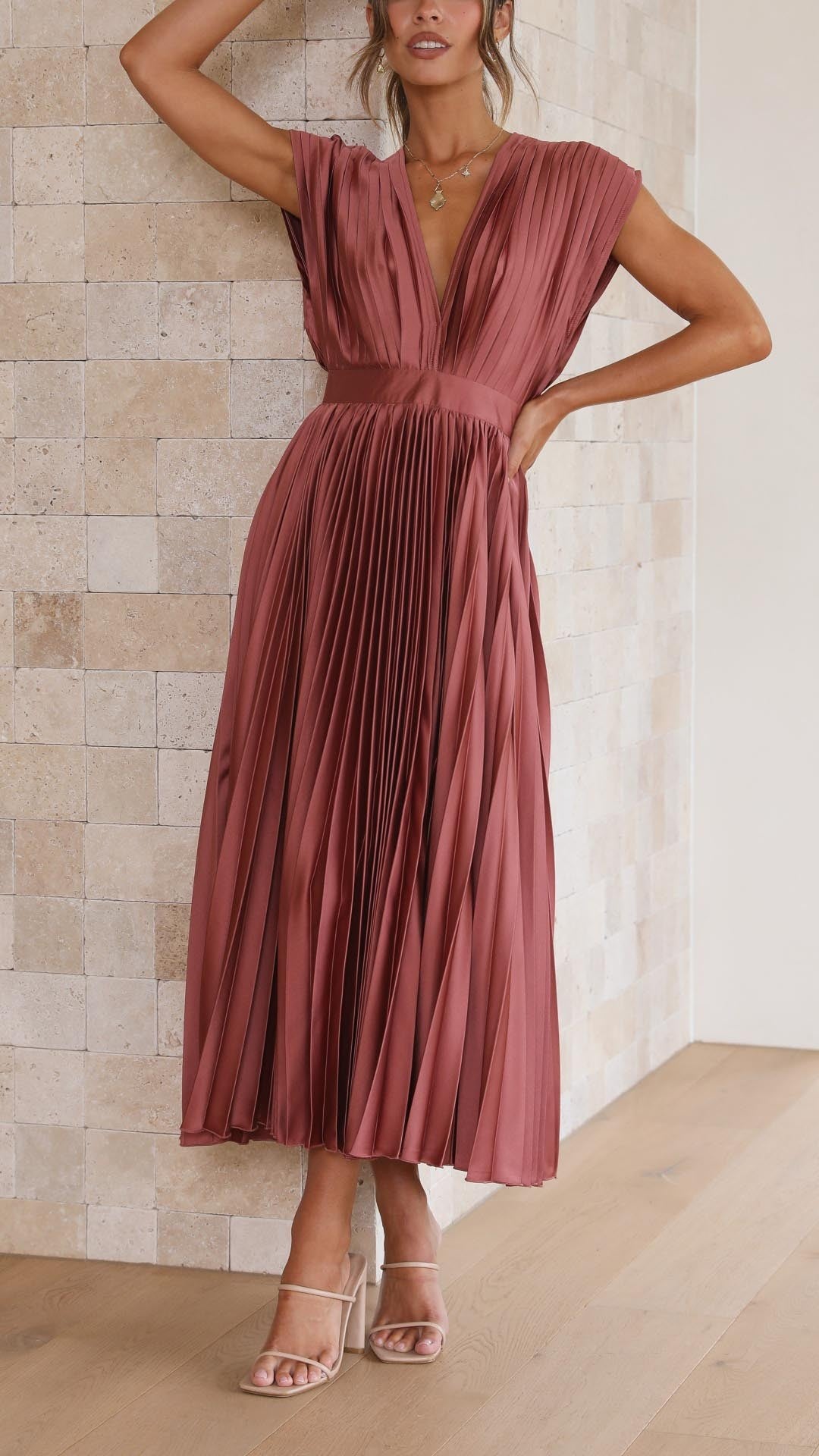 Rust pleated satin midi dress worn with nude strappy heeled sandals