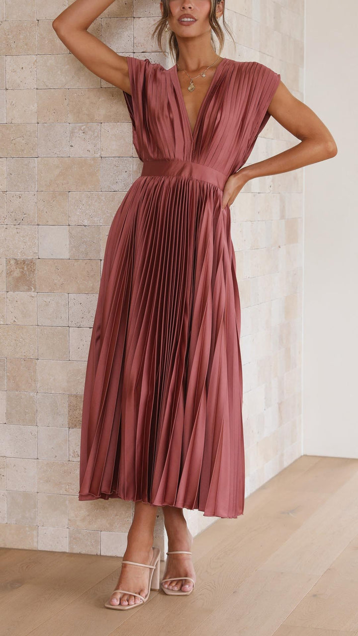 Rust pleated satin midi dress worn with nude strappy heeled sandals
