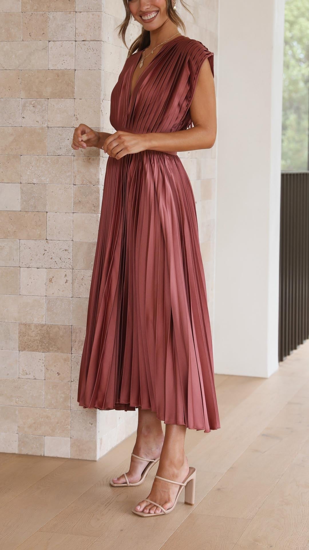 Side profile of rust pleated satin midi dress with cinched waistband