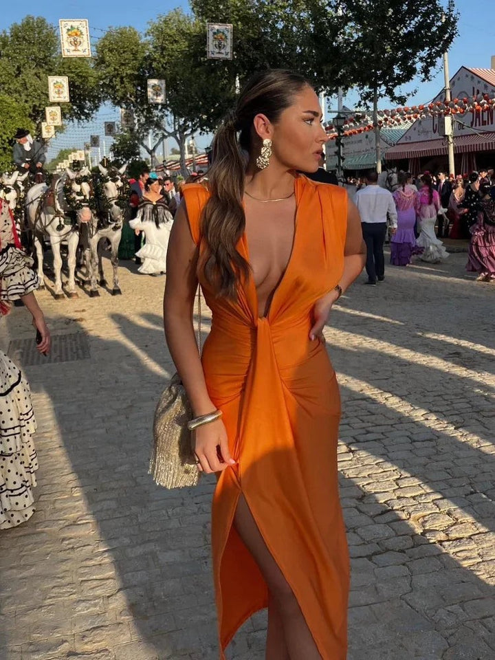 Orange ruched maxi dress with thigh-high slit worn at outdoor event
