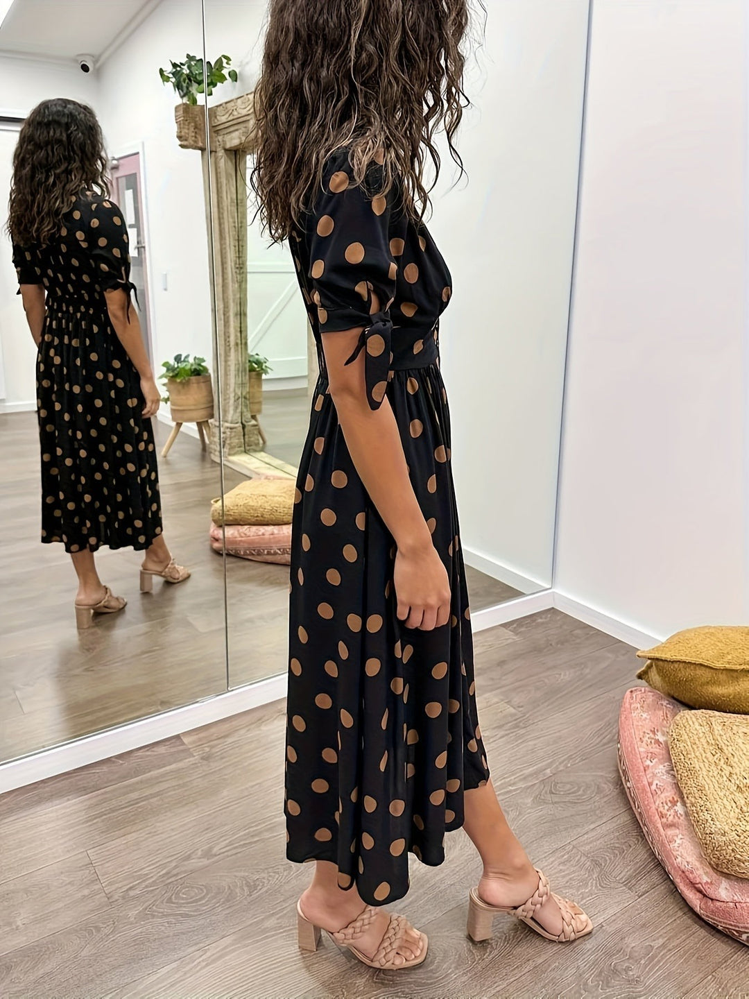 Polka dot midi dress with hand in pocket showing button placket detail