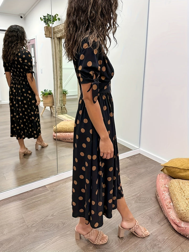 Polka dot midi dress with hand in pocket showing button placket detail