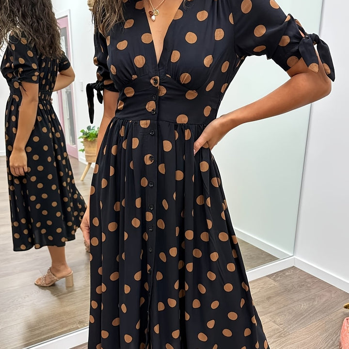 Side profile of flowing polka dot midi dress with tied sleeve cut-out