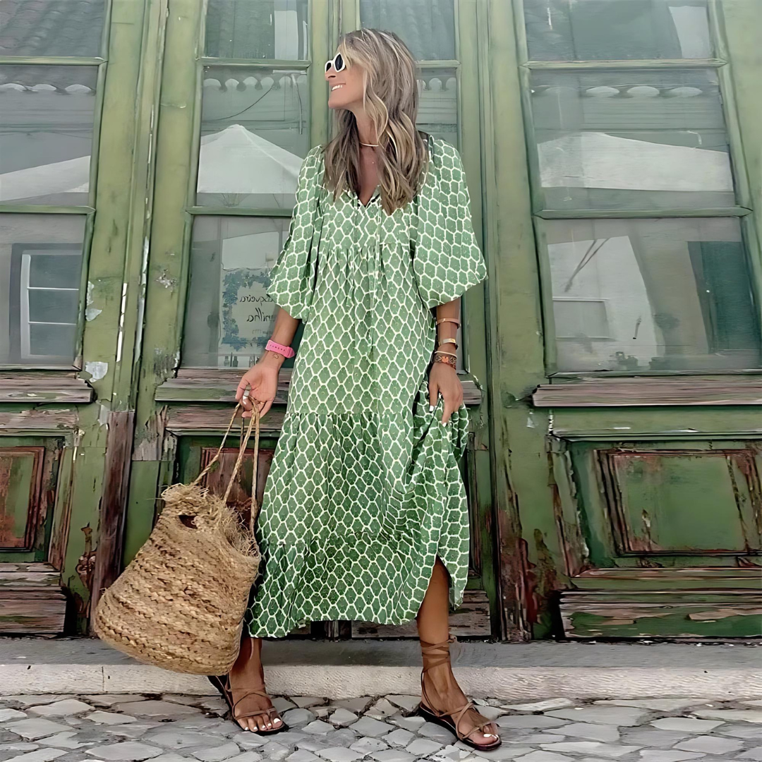 Flowy trellis print maxi dress in green with V-neckline and tiered skirt, worn with strappy sandals