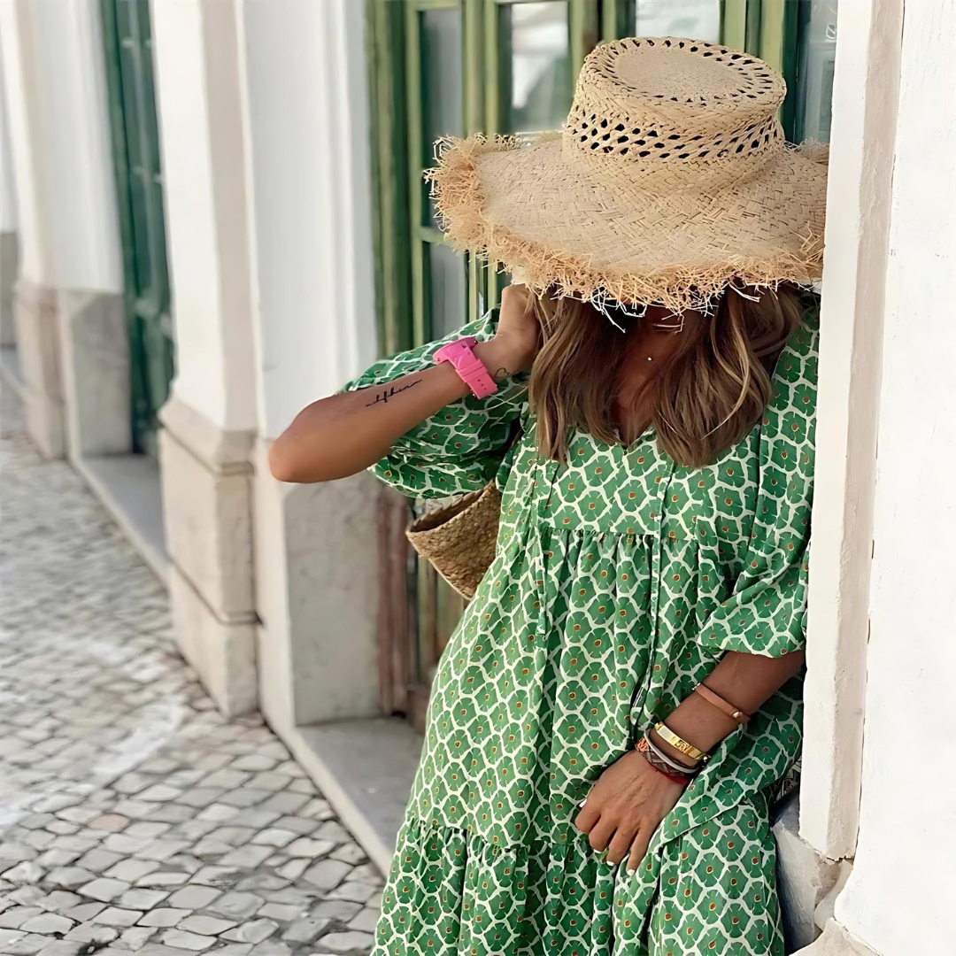 Green geometric print maxi dress with tiered ruffle hem, styled with straw hat and woven bag
