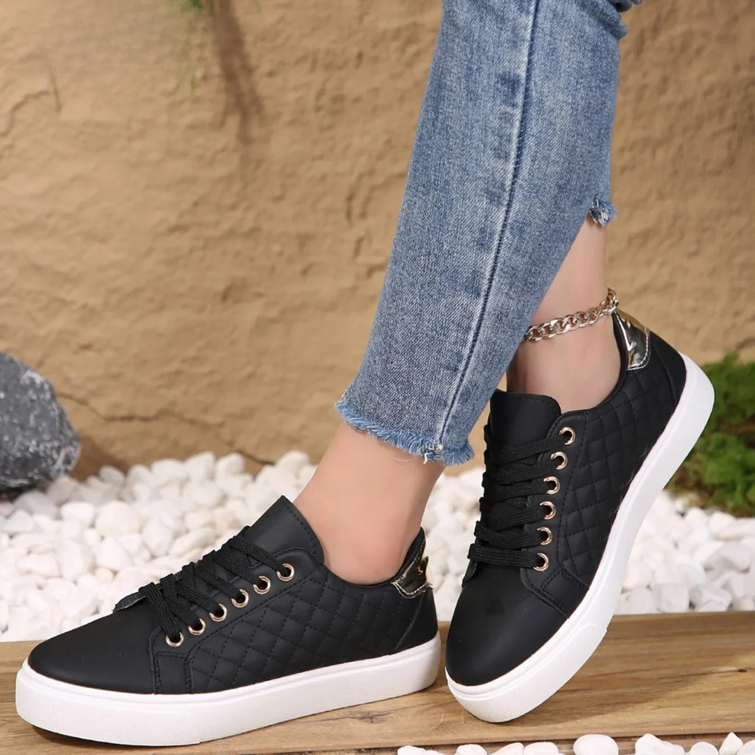 Black quilted Clarice orthopaedic trainers styled with cropped denim jeans