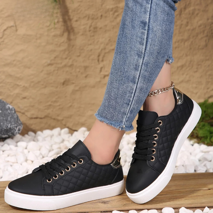 Black quilted Clarice orthopaedic trainers styled with cropped denim jeans
