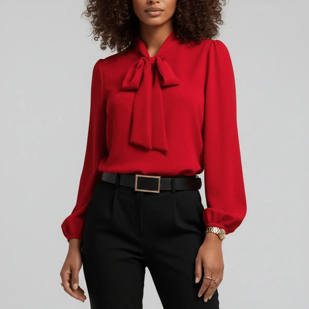 Red bow tie neck blouse with puffed sleeves, close-up front view