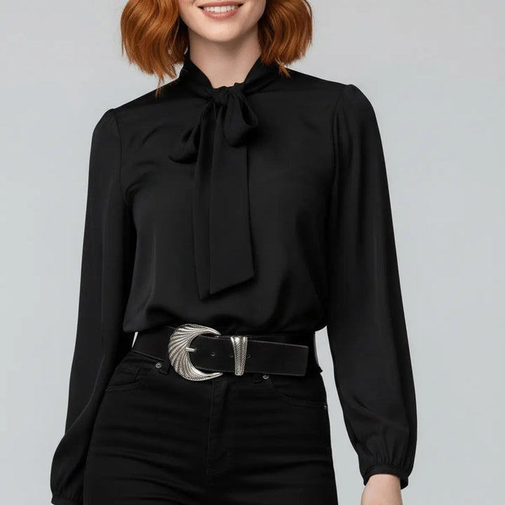 Black bow tie neck blouse with silver buckle belt, close-up view