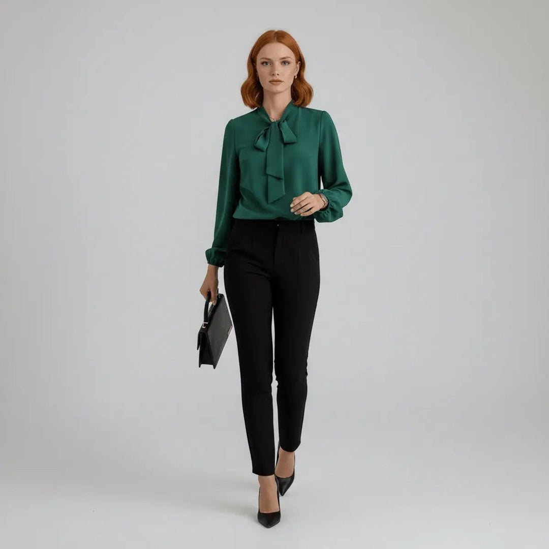 Green pussy-bow blouse worn with black high-waisted trousers, full-length