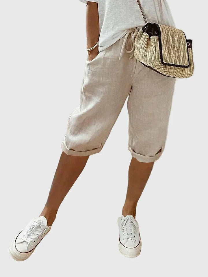 Beige linen-blend cropped trousers featuring rolled hems and elasticated drawstring waist