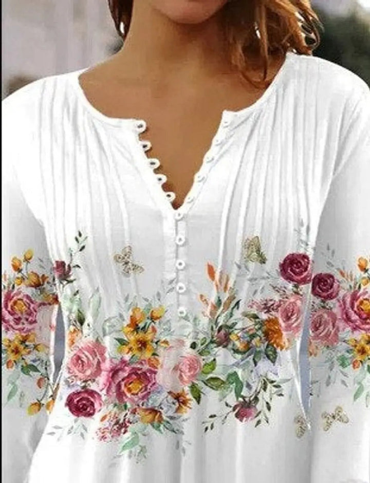 Close-up of white henley blouse featuring pink rose print and pintuck detailing