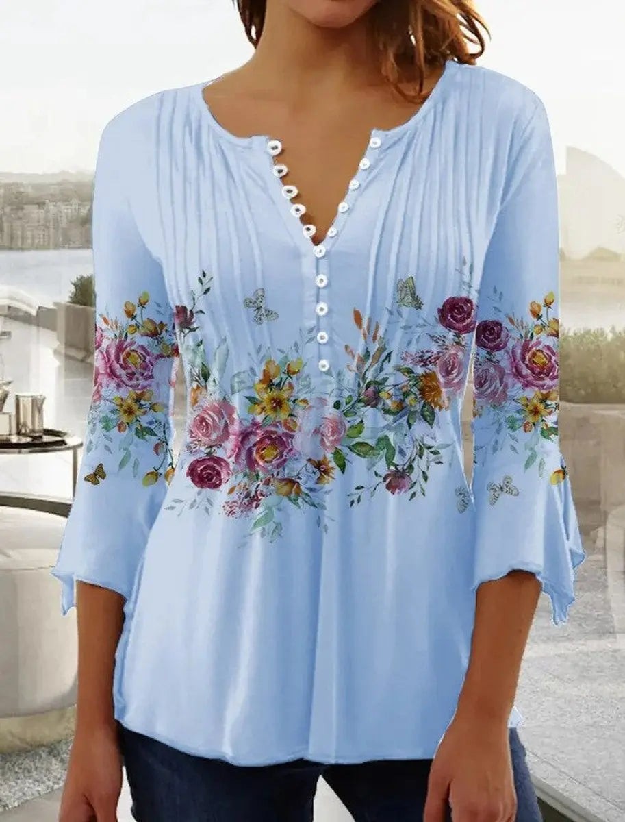 Pale blue floral henley blouse with flared cuffs and button-up neckline