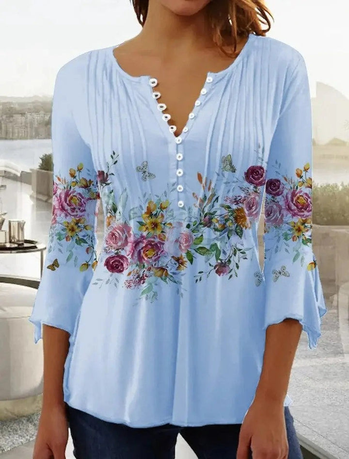 Pale blue floral henley blouse with flared cuffs and button-up neckline