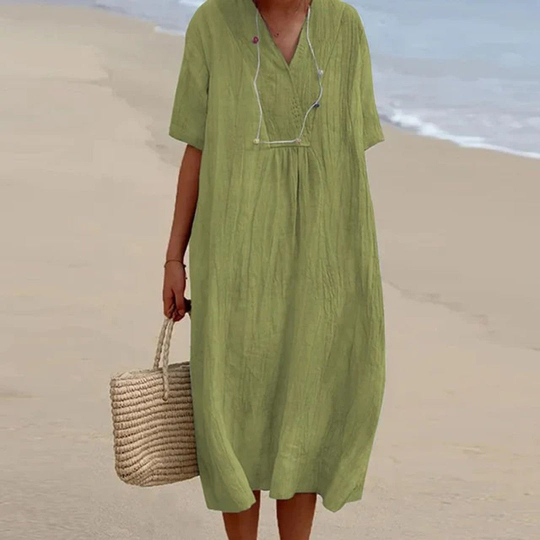 Olive green relaxed-fit V-neck midi dress paired with woven straw bag