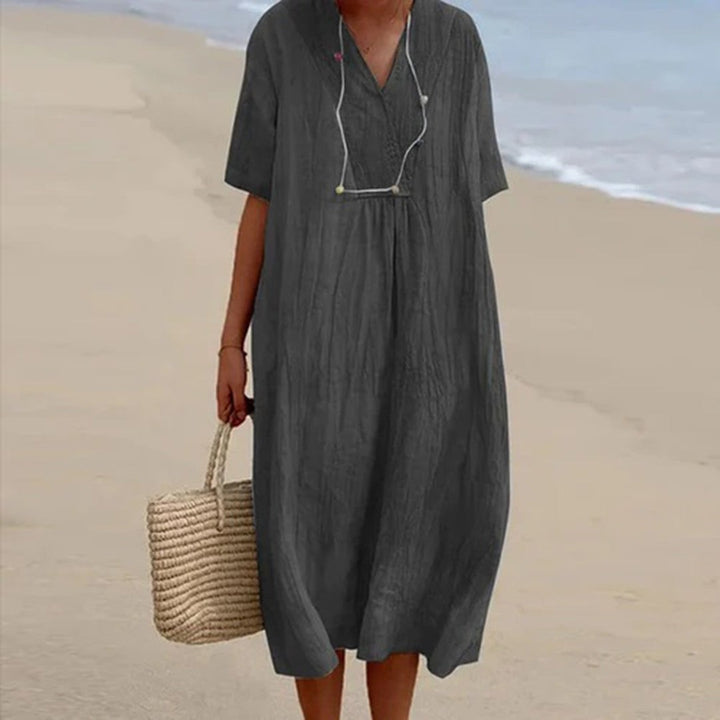 Charcoal grey relaxed-fit midi dress with V-neck, styled with straw tote