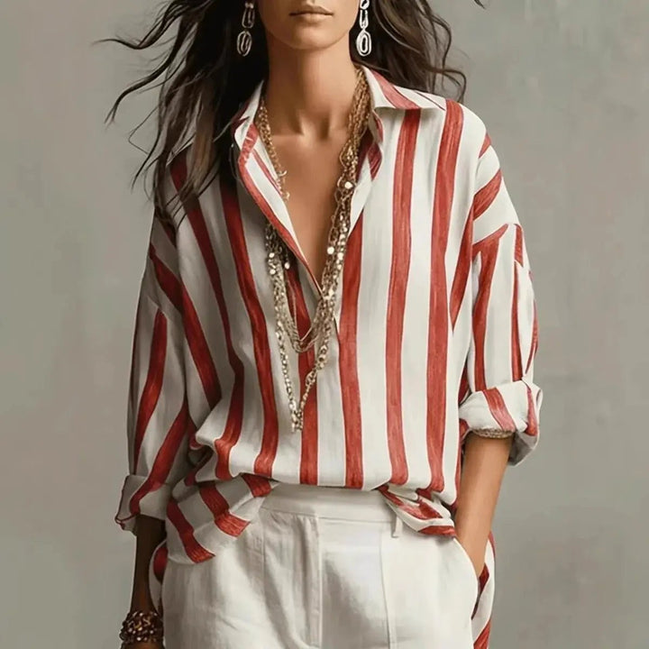 Red and white vertical striped collared blouse worn with white tailored trousers