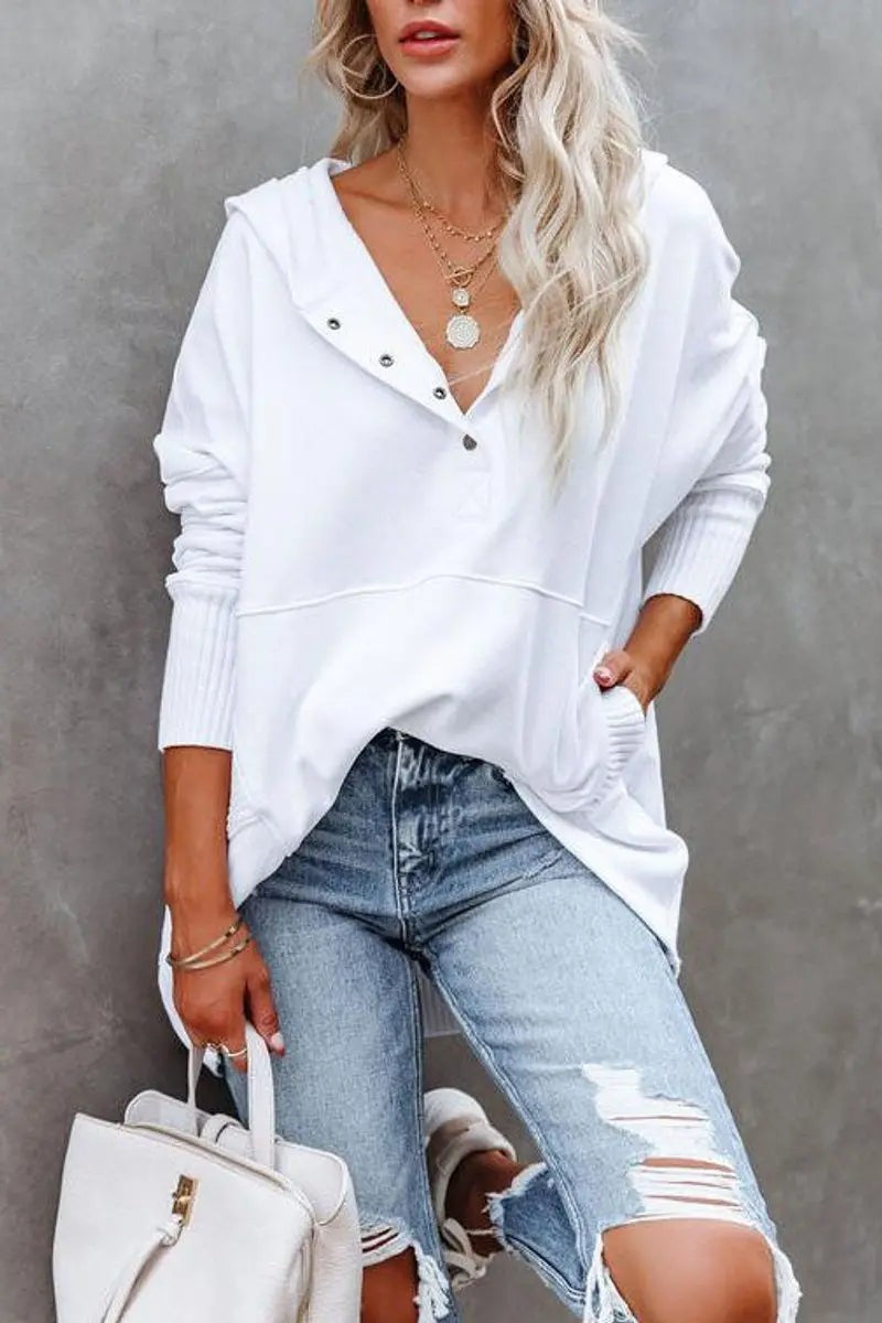 Close-up of white oversized hoodie with ribbed cuffs and popper fastening