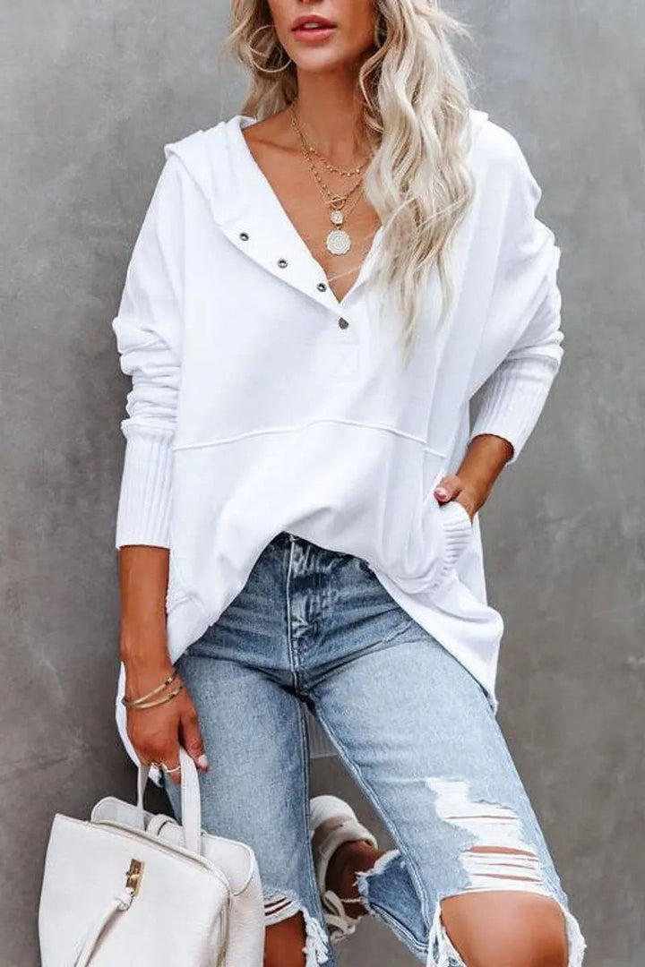 Close-up of white oversized hoodie with ribbed cuffs and popper fastening