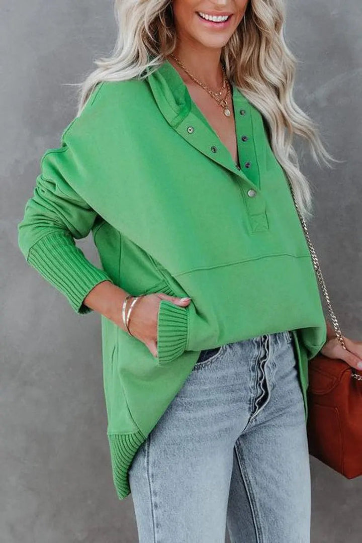 Green snap-neck hoodie tunic paired with light-wash denim jeans