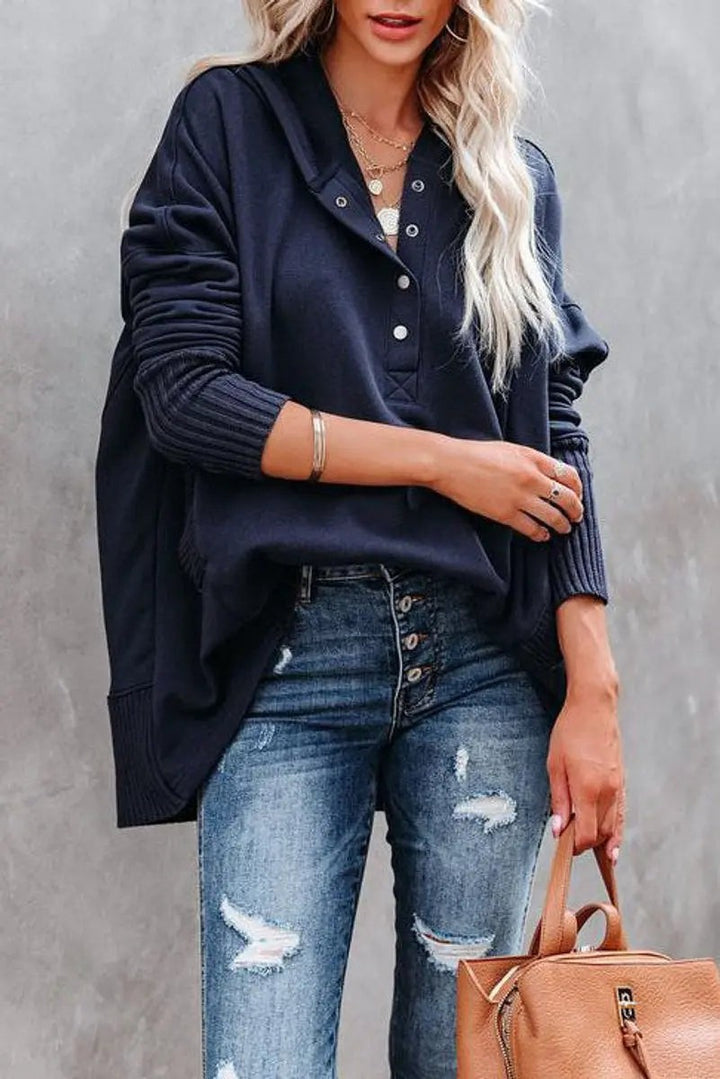 Close-up of navy hooded sweatshirt with snap buttons and ribbed cuffs