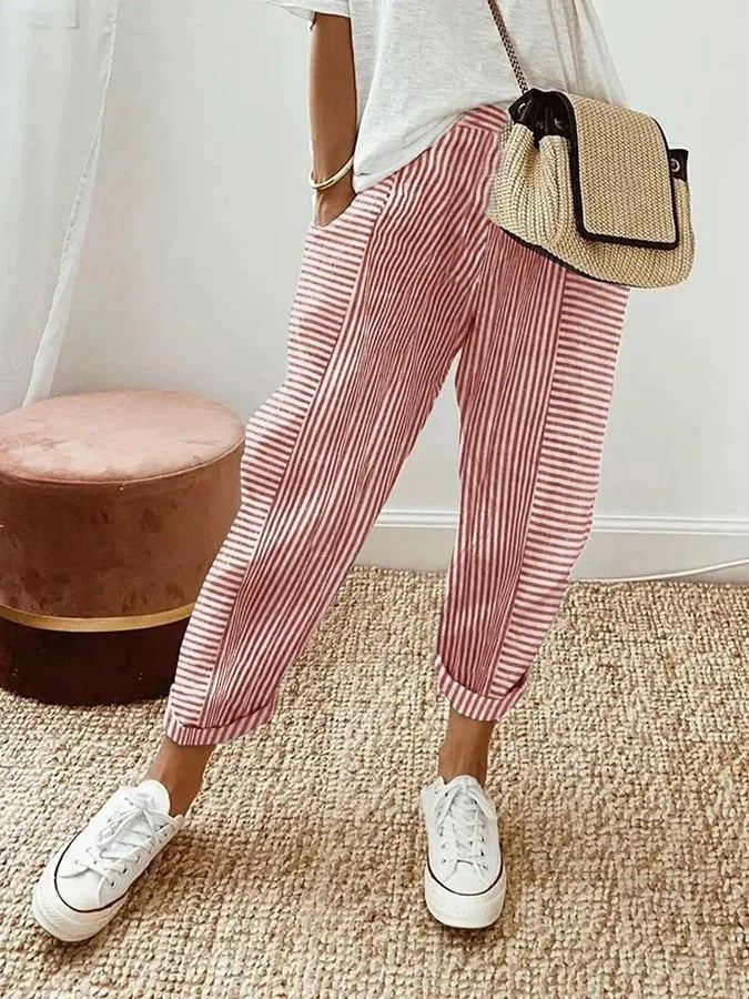 Red striped cropped trousers with turned-up hems, styled with white trainers