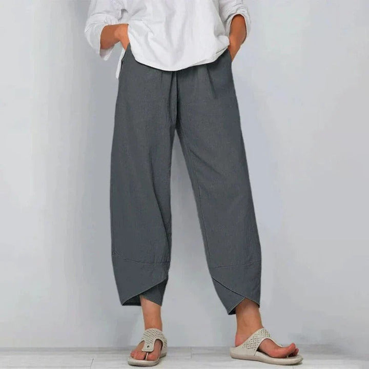 Charcoal grey lantern-style trousers featuring a tapered cross-hem finish